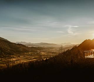 Blick über die Berge bei Sonnenuntergang mit Infinitypool