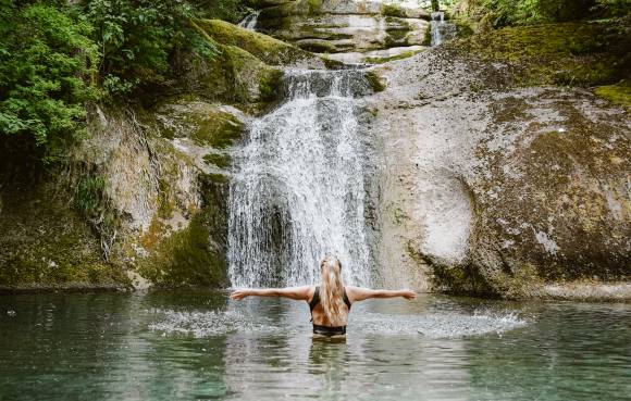 Frau im Wasserfall beim Eisbaden