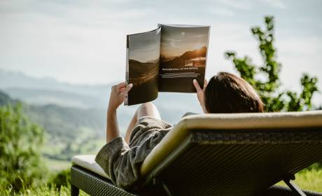 Frau ließt Magazin auf Liegewiese